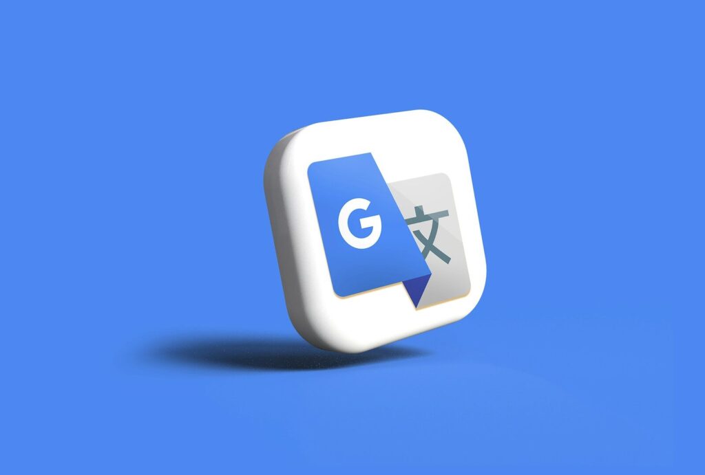 青い背景に描かれたGoogle翻訳アプリのロゴの3Dアイコン。青い四角の中に白い「G」が、灰色の四角の中に日本語の文字が描かれており、多言語サイトやGEO対策の戦略を説明するのに最適です。.